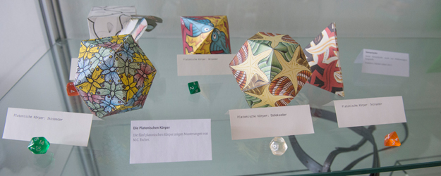 Eine der ausgestellten Vitrinen beherbergt die fünf Platonischen Körper mit Mustern des niederländischen Künstlers und Grafikers M. C. Escher. (Foto: Peter Pulkowski) Eine der ausgestellten Vitrinen beherbergt die fünf Platonischen Körper mit Mustern des niederländischen Künstlers und Grafikers M. C. Escher. (Foto: Peter Pulkowski)