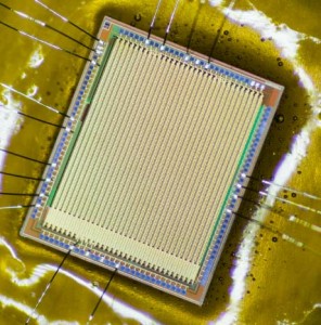 Microscope view of a MUPIX chip prototype – actual size ca. 4 by 5 mm. The chip has been thinned and is mounted on a 25 _m polymide foil. The bond wires connect it to a readout PCB.