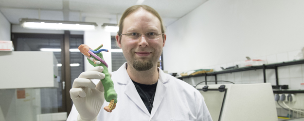 Dr. Meik Neufurth mit einem Modell einer Arterie, hergestellt mithilfe eines 3-D-Druckers an der Universitätsmedizin Mainz (Foto: Peter Pulkowski)