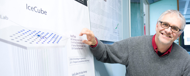 Prof. Dr. Lutz Köpke vom Institut für Physik erklärt anhand einer Darstellung des IceCube-Detektors dessen komplizierten Aufbau. (Foto: Peter Pulkowski)